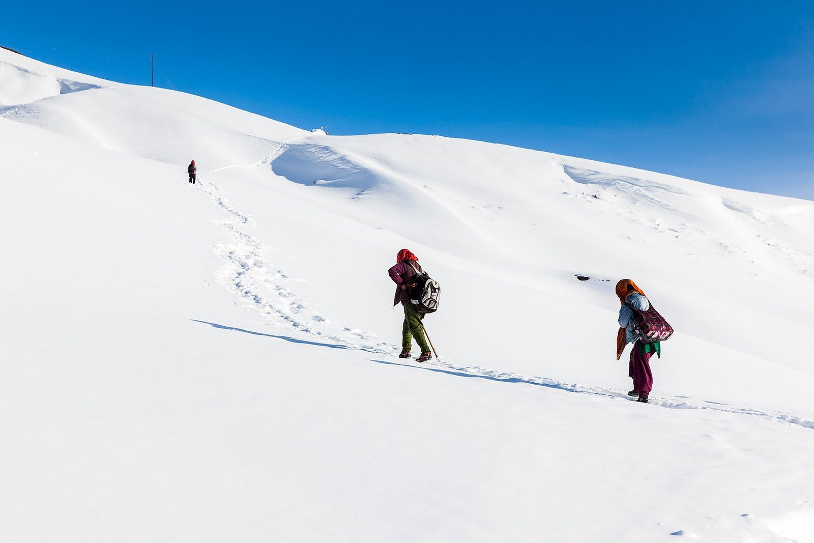 Two people crossing a snowfield in Spiti in winter